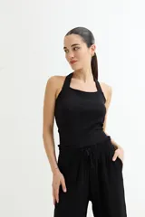 Musculosa negra con escote halter y espalda descubierta.