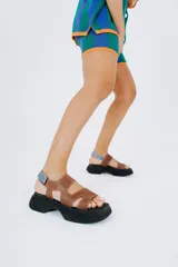 Sandalias de cuero color chocolate con plataforma negra y ajuste con velcro trasero.