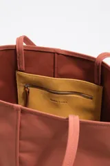 Bolso shopper grande Bimba Y Lola de color amarillo, con exterior de nylon, asas de hombro y detalles en piel. Cuenta con cierre de mosquetón y logo metálico de la marca en la parte frontal.