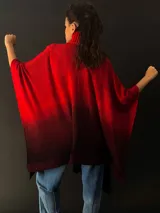 Ruana larga de lana merino color gris con cuello plisado de fieltro. Diseño degradado con terminación en flecos.