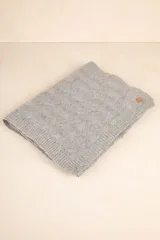 Bufanda rectangular tejida color gris con pequeños puntos de color.