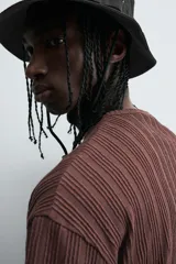 Camiseta de algodón de corte relajado (relaxed fit) color marrón oscuro, con cuello redondo y manga corta. Presenta una textura acanalada vertical tipo jacquard.