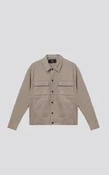 Chaqueta de corte regular crop confeccionada en microfibra pesada levemente elastizada. Presenta cuello volcado, cierre frontal con broches snap a tono y bolsillos delanteros con solapa.