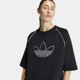 Remera Adidas de corte oversize, color negro, con cuello redondo y mangas cortas. Presenta el logo del Trifolio de la marca bordado en contorno blanco en el centro del pecho y detalles de líneas blancas en las costuras de las mangas.