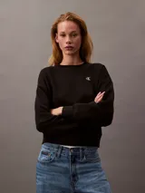 Buzo negro de cuello redondo, confeccionado en tejido fleece de mezcla de algodón y poliéster. Presenta el logo de archivo de Calvin Klein bordado en blanco en el frontal.