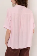 Camisa de manga corta color blanco con cuello mao y cierre frontal de botones. Presenta detalles bordados tono sobre tono en el canesú y diseño de corte recto.