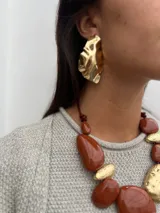 Aros dorados con diseño irregular y acabado brillante, que simulan la forma de una duna.