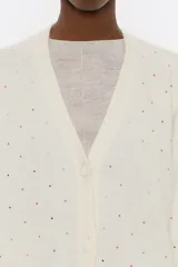 Cárdigan negro de corte recto en mezcla de mohair, con escote pico pronunciado, manga larga, cierre frontal con botonadura y piedras por toda la prenda.