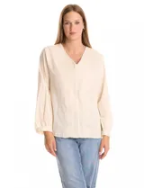 Blusa de algodón en color beige con bordado floral al tono. Presenta escote en V con terminación festoneada, mangas largas sutilmente abullonadas con puños fruncidos y una silueta fluida y relajada.