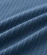 Remera de manga corta, color azul, con textura acanalada vertical. Presenta cuello redondo y puños contrastantes en color beige.