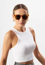 Lentes de sol con armazón de acetato biodegradable en color ámbar translúcido y diseño cuadrado ligeramente extragrande. Cuentan con lentes oscuros con protección UV 400.