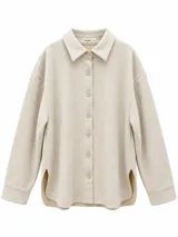 Sobrecamisa de gamuza sintética color beige, de corte holgado, con cuello clásico, mangas largas con puños abotonados y cierre frontal con botones. Presenta dobladillo redondeado con aberturas laterales y un forro interior en tono contrastante.