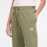 Pantalón de jogging New Balance de corte holgado, con tiro medio y puños elásticos en los tobillos. Presenta un diseño minimalista con marca discreta en la pierna.