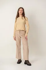 Pantalon de pana color beige, de corte recto y tiro medio, con cierre frontal y bolsillos laterales.