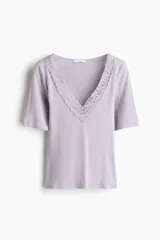 Top entallado color lila en punto acanalado suave, con mangas cortas y escote en V pronunciado ribeteado en encaje.