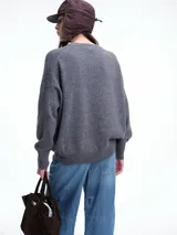 Sweater de tejido de punto en color rosa claro con motas de colores, de corte holgado, cuello redondo y mangas largas con hombros caídos.