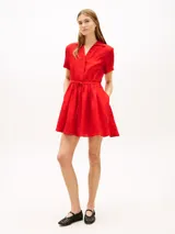 Vestido corto rojo de lino de Tommy Hilfiger, con cuello camisero, manga corta, cierre frontal con botones ocultos, cordón ajustable en la cintura y bolsillos laterales.