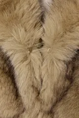 Abrigo corto de piel sintética con cuello de solapa, manga larga y bolsillos frontales. Cuenta con forro interior y cierre frontal con ganchos metálicos.