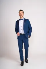 Ambo de ceremonia color azul, compuesto por saco con solapas de satén y pantalón de vestir a juego. Incluye camisa blanca y moño azul.