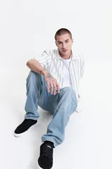 Jean cargo negro de tiro medio, con pasacinto, bolsillos laterales y bolsillos cargo con solapa en los muslos.