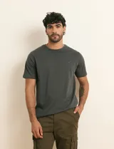 Remera básica de algodón color beige, de manga corta, con cuello redondo y un pequeño detalle bordado en el pecho.