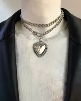 Collar doble de cadena plateada con dije de corazón con pinches.