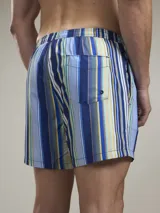Short de baño con estampado botánico en tonos naranja y coral, con cintura elástica ajustable mediante cordón y malla interior para mayor soporte.