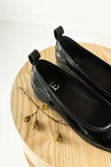 Zapato tipo ballerina color beige con correa al tobillo desmontable.