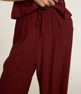 Pantalón recto de viscosa color bordó, con superficie texturizada y lazo ajustable en la cintura.