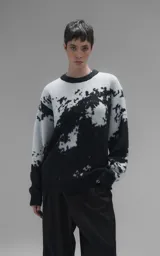 Sweater de punto con diseño abstracto tipo tie-dye o manchado en tonos gris y negro, de cuello redondo, manga larga y corte oversize. Presenta terminaciones en punto rib en cuello, puños y ruedo.