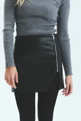 Falda corta de ecocuero con textura tipo croco, diseño cruzado con cierre metálico frontal y tajo lateral.