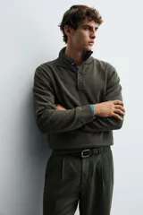 Jersey de punto de corte regular, con cuello perkins y cierre frontal parcial con botonadura. Presenta manga larga y acabados en rib en puños y bajo.