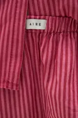 Pantalón de pijama de algodón con diseño de rayas verticales en tonos azul y bordó, corte holgado, cintura elástica y botamangas con vuelta.