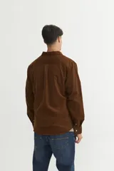 Camisa marrón de pana fina, corte regular fit, con cuello solapa clásico, bolsillo en el pecho y botones personalizados.