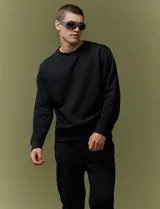 Sweater básico de cuello redondo y manga larga, confeccionado en tejido circular con puños y cuello en tejido canalé.