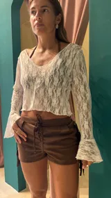 Blusa de encaje blanca con mangas largas acampanadas.