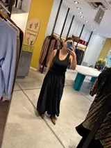 Pantalon negro de tiro alto con diseño plisado y corte amplio tipo palazzo, confeccionado en tejido con textura acanalada.