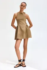 Vestido corto marrón sin mangas, con escote redondo y cierre oculto en la espalda. Cuenta con un diseño entallado en el cuerpo y una pollera acampanada con frunces en los laterales de la cadera.