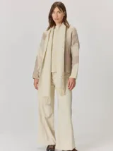 Bufandón de tejido de punto suave, con diseño liso y terminaciones con flecos en los extremos.