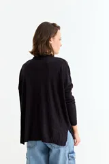 Cardigan negro de manga larga, con cuello camisero, botones frontales y un bolsillo en el pecho.