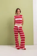 Pantalón acampanado tejido en algodón a rayas horizontales rojas y rosadas, con cintura elastizada y cordón de ajuste.