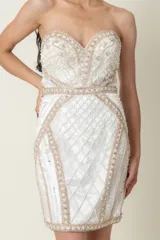 Vestido corto strapless blanco con bordados y apliques de piedras blancas, plateadas y color nude. Corte ajustado con falda recta. Ideal para civil o fiesta.