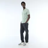 Remera polo de piqué color verde menta, con cuello y puños acanalados en tono contrastante, cierre frontal con botones y bordado sutil en el pecho.
