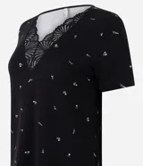 Pijama largo negro de viscolycra con estampa floral, compuesto por una remera de manga corta con escote en V y aplicación de encaje, y un pantalón con cintura elastizada.
