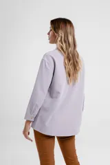 Camisa magenta de corte holgado con cuello clásico y cierre frontal con botones.