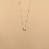 Conjunto de tres collares de cadena fina en plata 925 con baño de oro, cada uno con un dije de punto de luz en forma de circonia engastada.