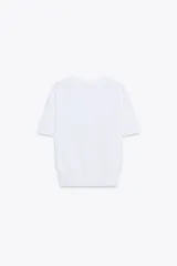 Jersey de punto fino con cuello redondo y manga corta, con terminaciones en rib en cuello, mangas y ruedo.