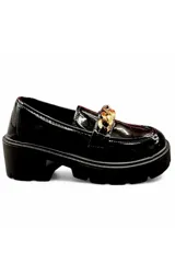Mocasín de mujer color negro en material charolado, con suela track gruesa y detalle de cadena dorada en el empeine.