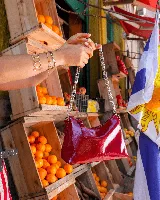 Cartera tipo hobo con diseño de media luna, confeccionada en cuero natural con acabado charol brillante. Presenta una correa de cadena metálica plateada y cierre superior con tirador de cuero. Incluye forro interior y bolsillo con cierre.