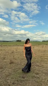 Vestido largo de corte sirena con diseño geométrico de rombos en colores violeta y naranja. Presenta breteles finos, escote recto y una falda con caída fluida que termina en una pequeña cola.